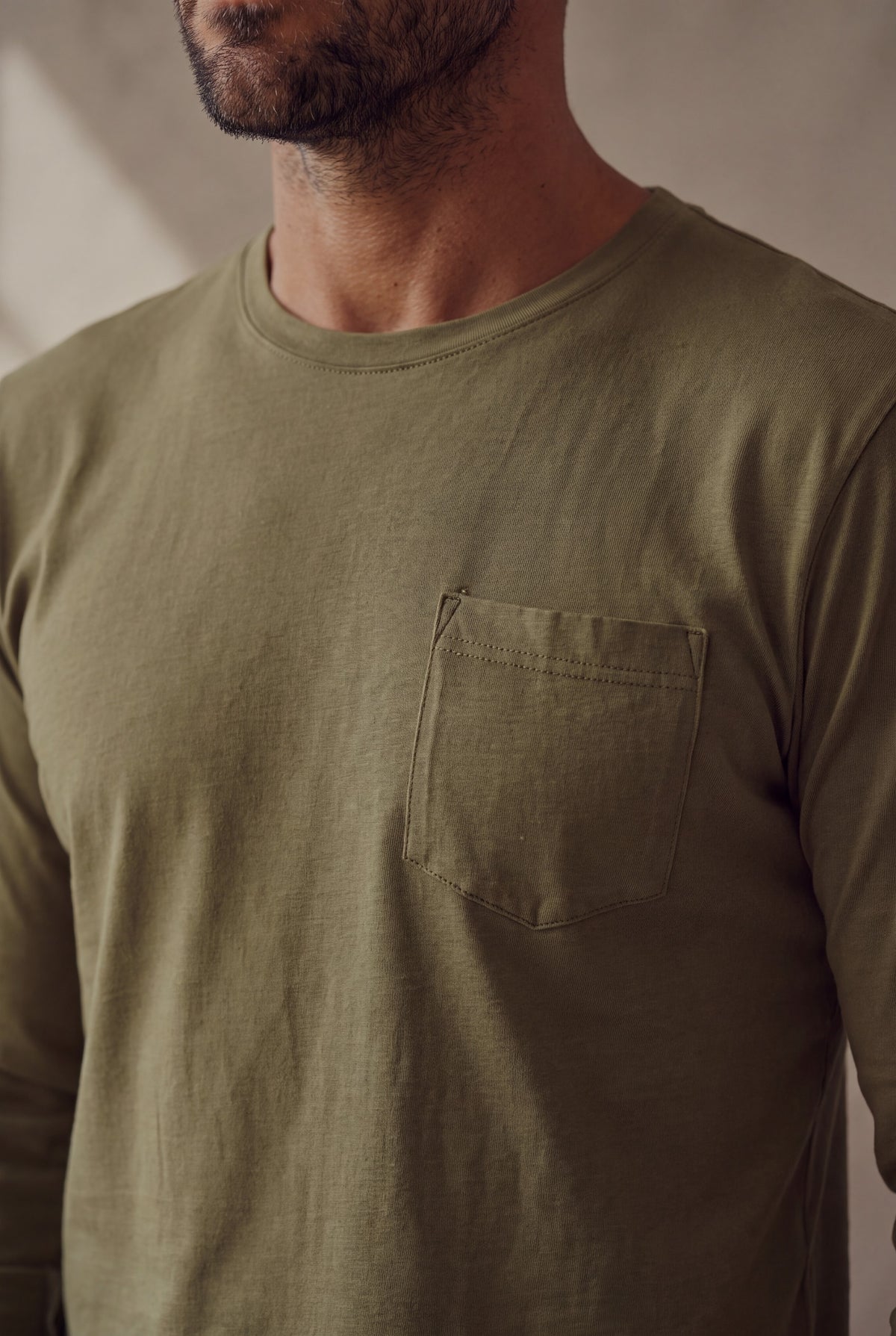 Detalle del cuello y el bolsillo de la camiseta de manga larga cuello redondo Verde Militar; Luck and Load