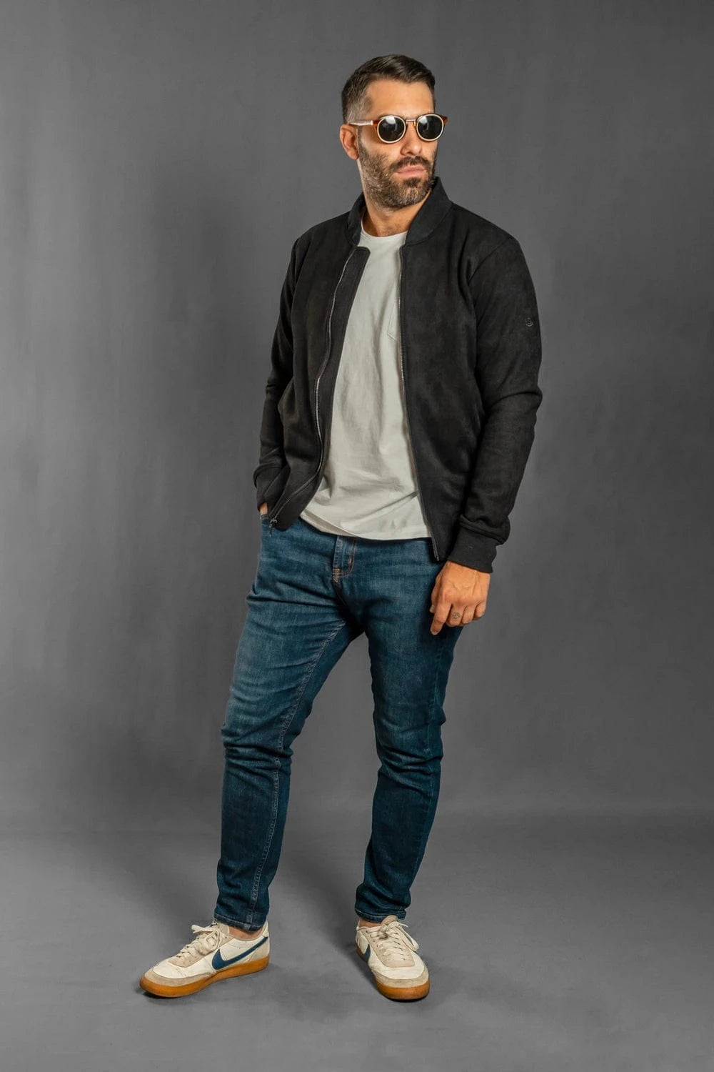 Chaqueta bomber negra Luck & Load para hombre — vista frontal cuerpo entero con jeans y camiseta, gamuza sintética