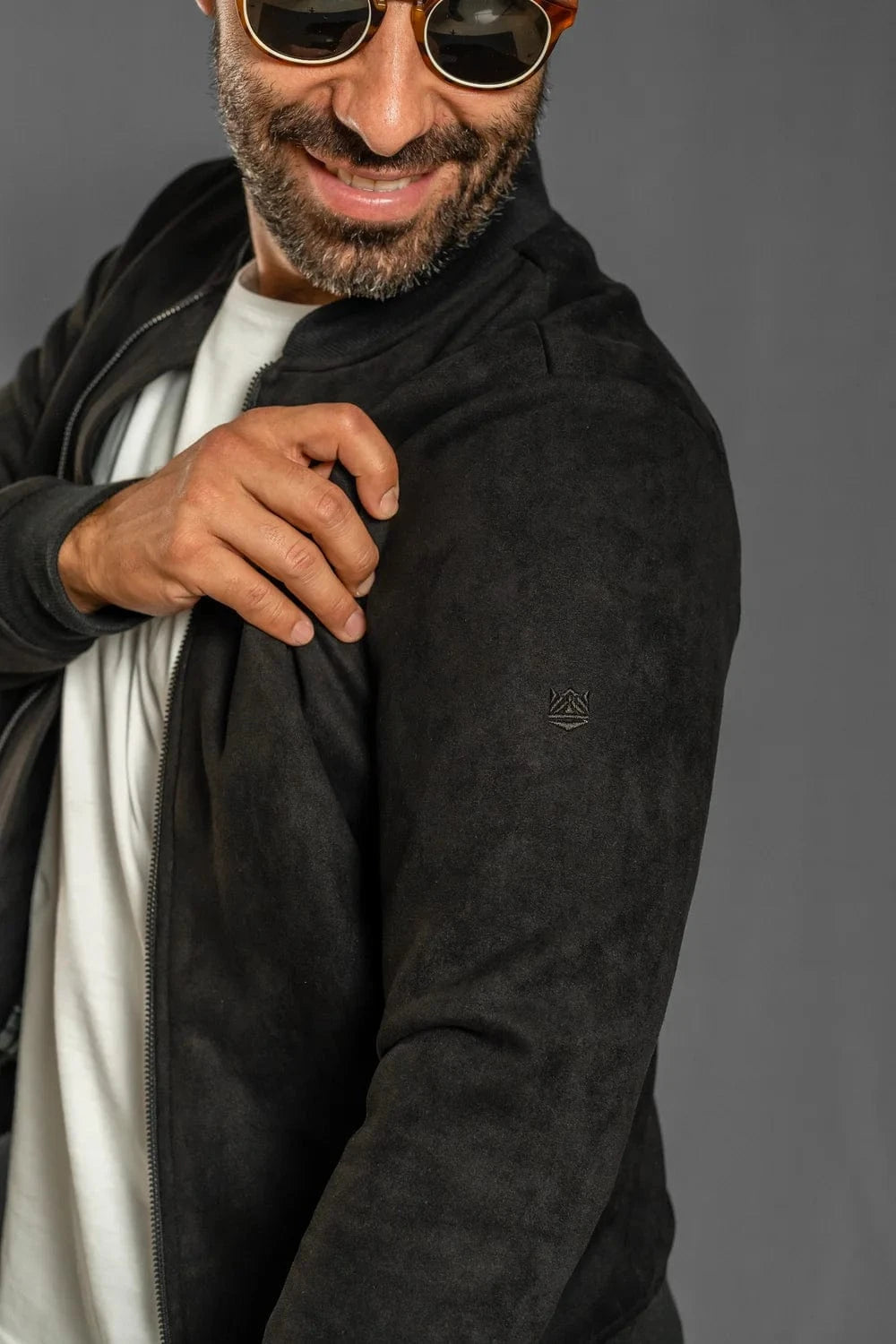 Detalle logo en manga de chaqueta bomber negra Luck & Load para hombre — zoom gamuza sintética, estilo urbano 2025