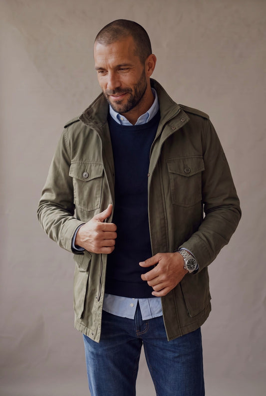 Chaqueta militar para hombre en verde oliva con sueter azul, plano medio cuerpo casual, Luck and Load