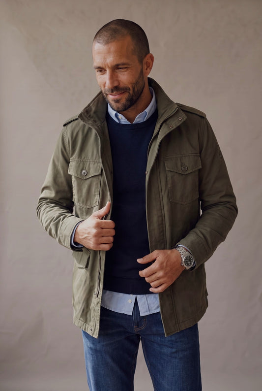 Chaqueta militar para hombre en verde oliva con sueter azul, plano medio cuerpo casual, Luck and Load