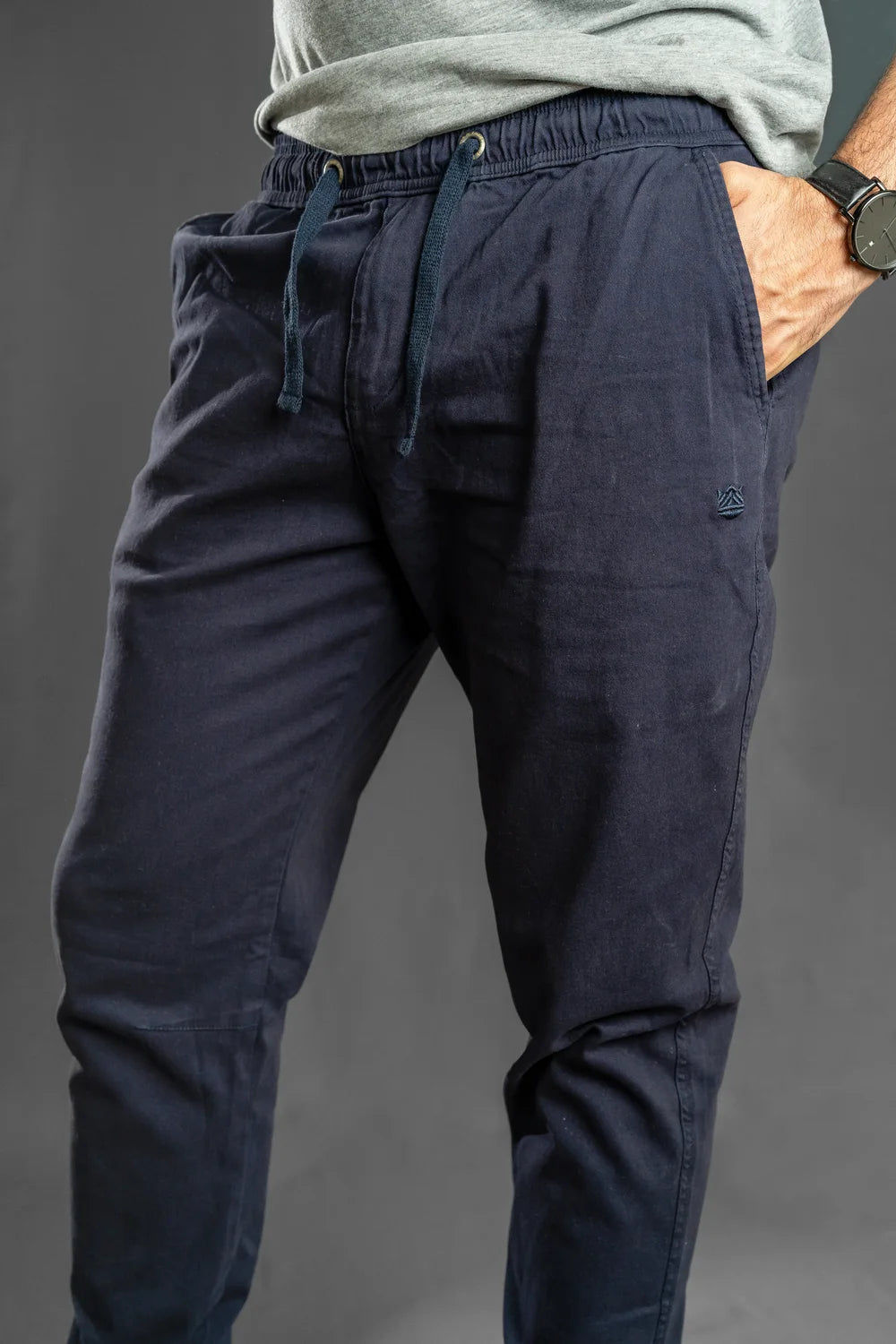 Zoom al bolsillo y cintura del jogger azul marino, pantalón con puño que combina con tenis blancos