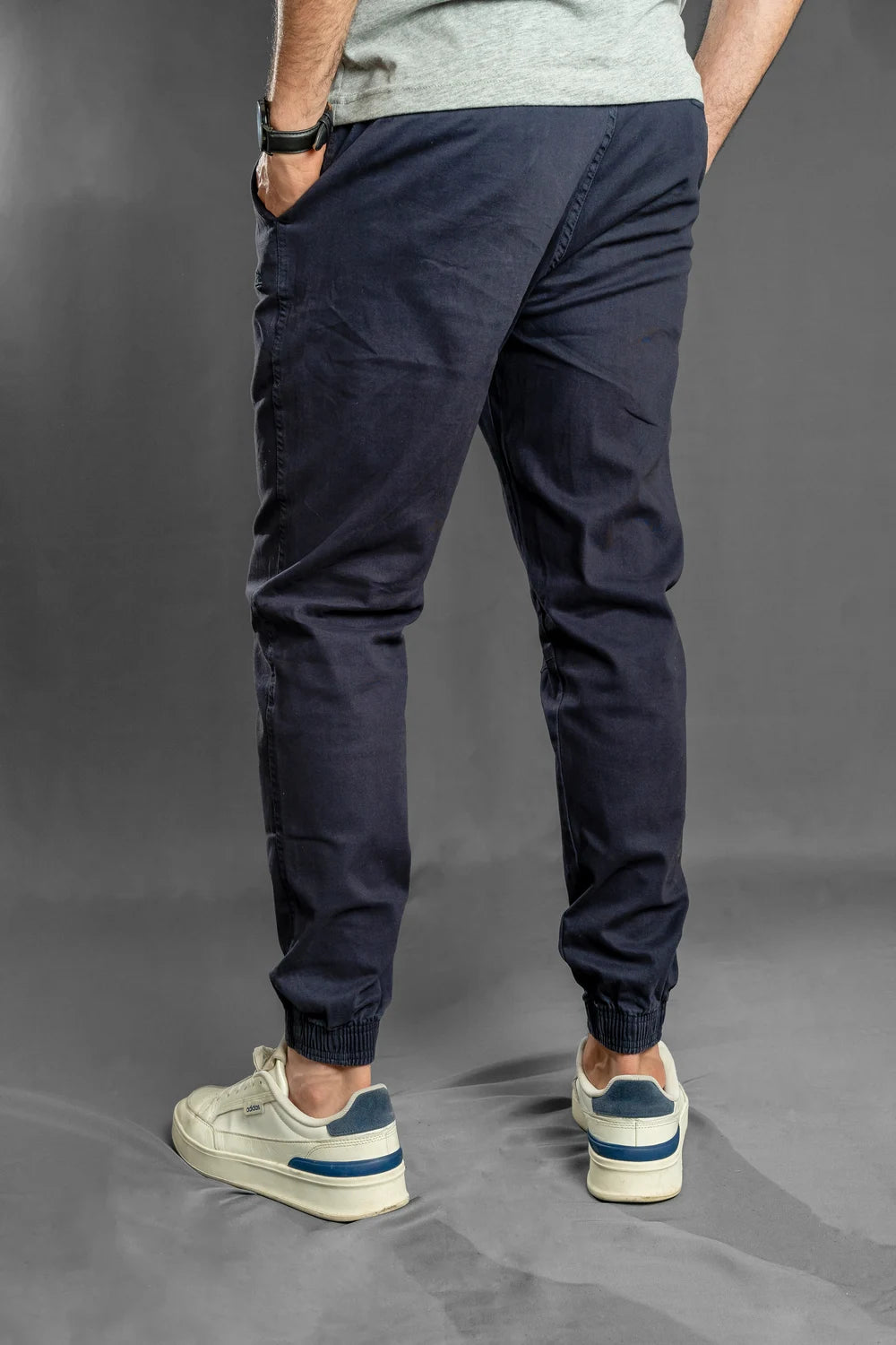 Vista trasera de pantalón jogger azul marino, puños resortados y corte tapered para uso diario
