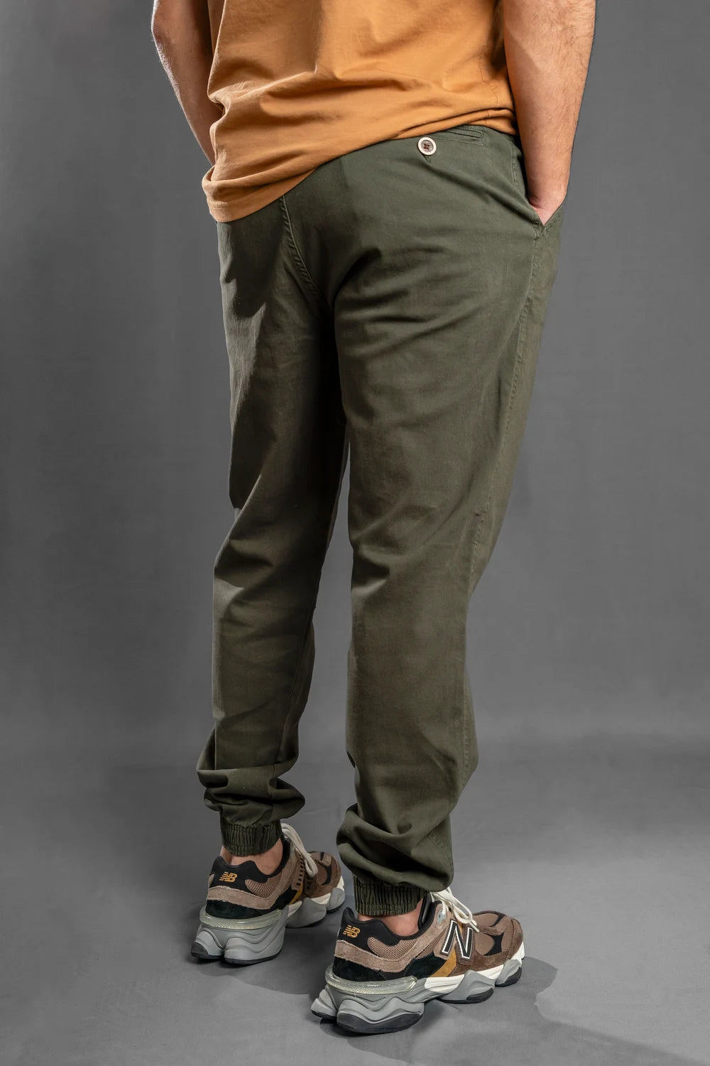 Parte trasera del jogger verde militar con puños resortados y bolsillos laterales, estilo casual colombiano