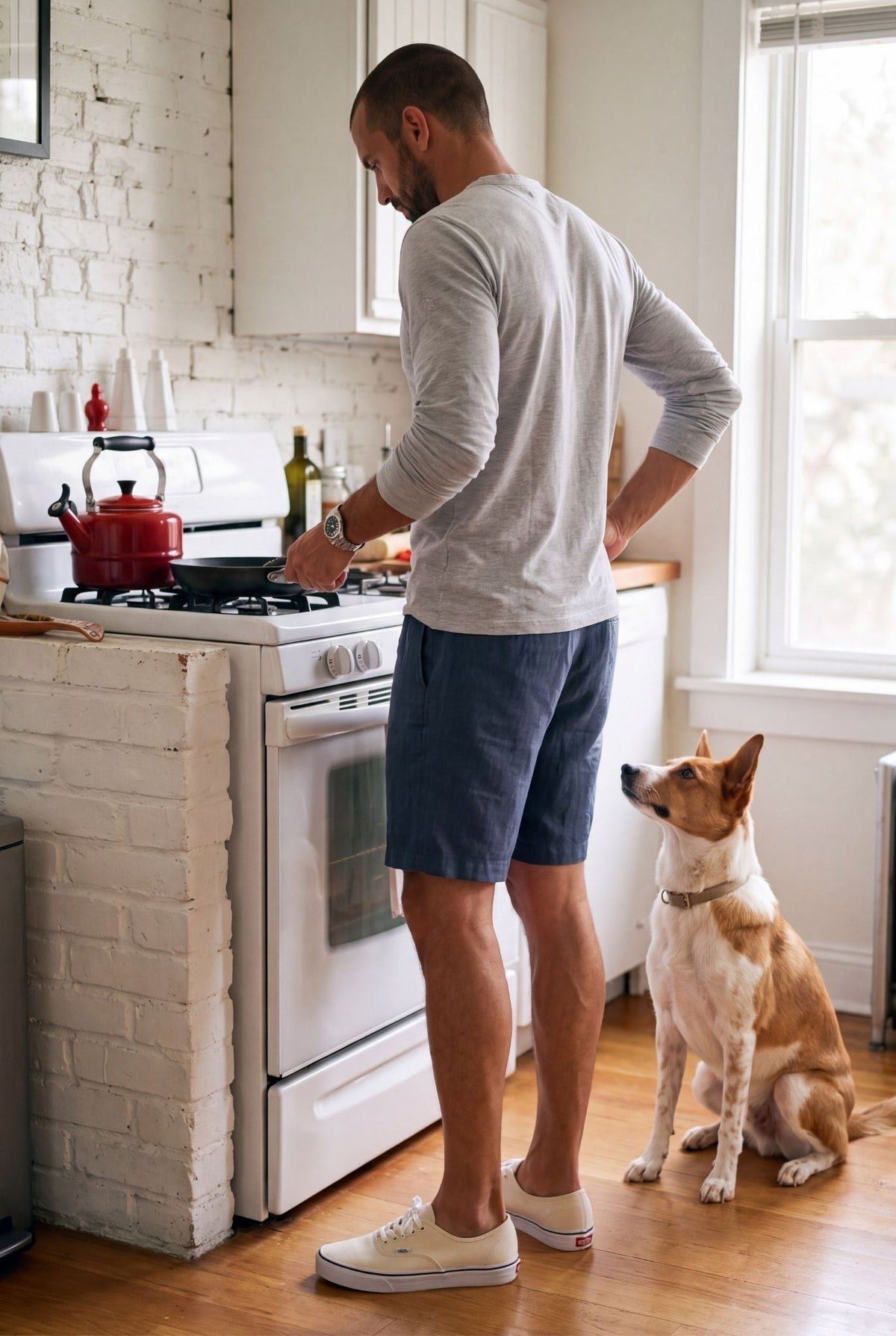 Hombre cocinando en casa con bermuda de descanso azul naval; estilo de vida Luck & Load.