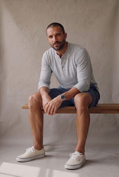 Hombre sentado con bermuda de descanso azul naval y henley gris jaspe de Luck & Load.