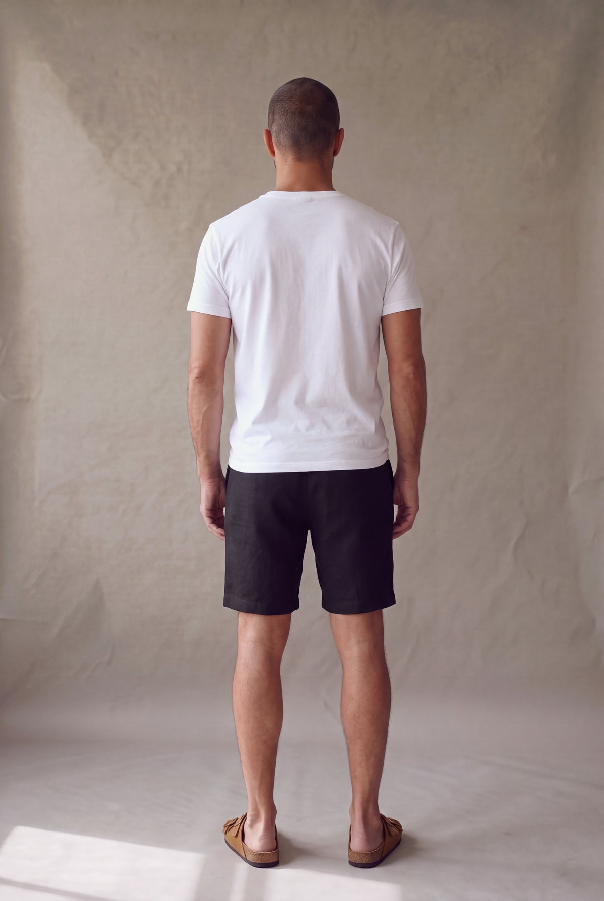 Bermuda de descanso negra para hombre, vista de espalda; corte limpio sin bolsillos traseros. Luck & Load.