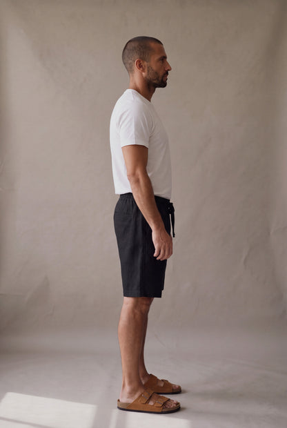 Bermuda de descanso negra para hombre, vista lateral; bolsillo lateral y largo arriba de la rodilla. Luck & Load.
