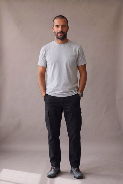 Hombre de frente con camiseta gris de cuello redondo con bolsillo en algodon peruano, foto de catalogo en estudio.