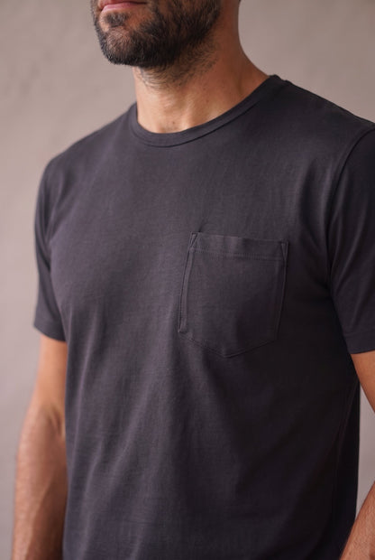 Detalle del bolsillo de pecho pentagonal de la camiseta negra de cuello redondo en algodón peruano