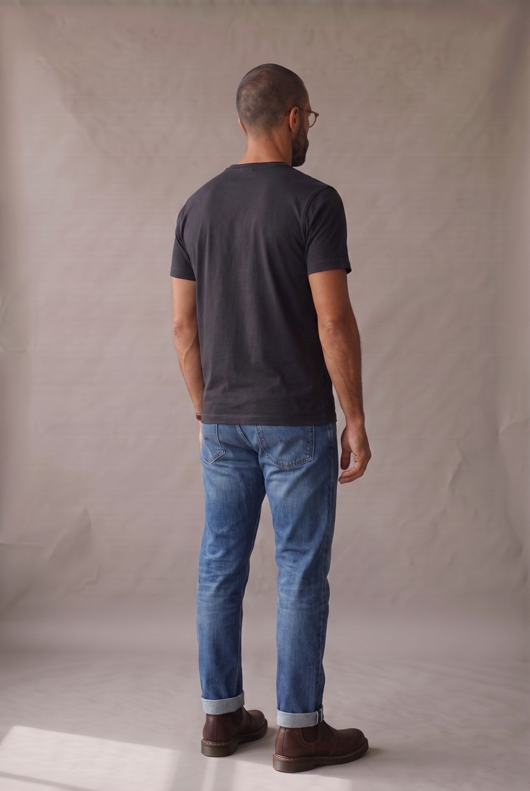 Vista de espalda de la camiseta negra de cuello redondo con bolsillo, corte recto en algodón peruano