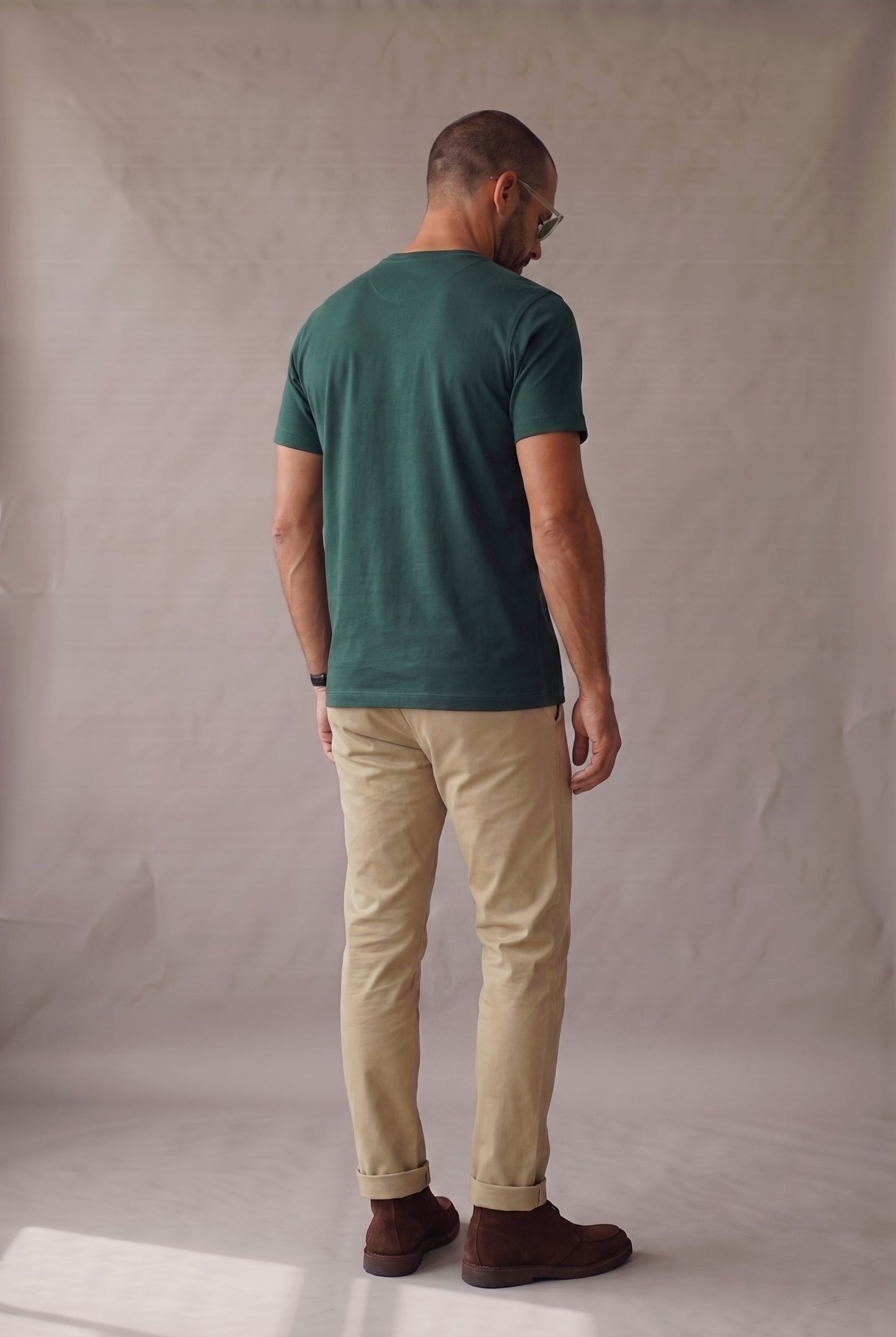 Vista de espalda de la camiseta verde pino de cuello redondo con bolsillo en algodon peruano, corte recto.