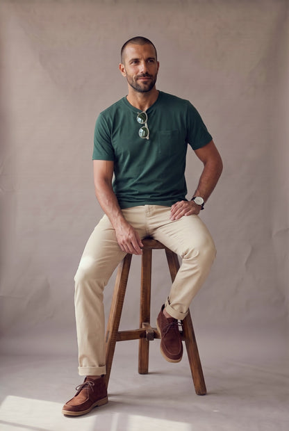 Camiseta verde pino de bolsillo en algodon peruano en plano medio, mostrando el calce en un hombre.