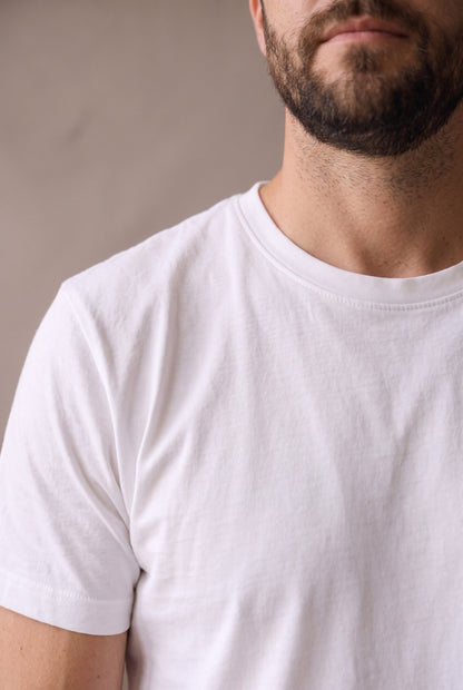 Primer plano del cuello redondo y la costura de hombro de la camiseta blanca de Luck & Load.