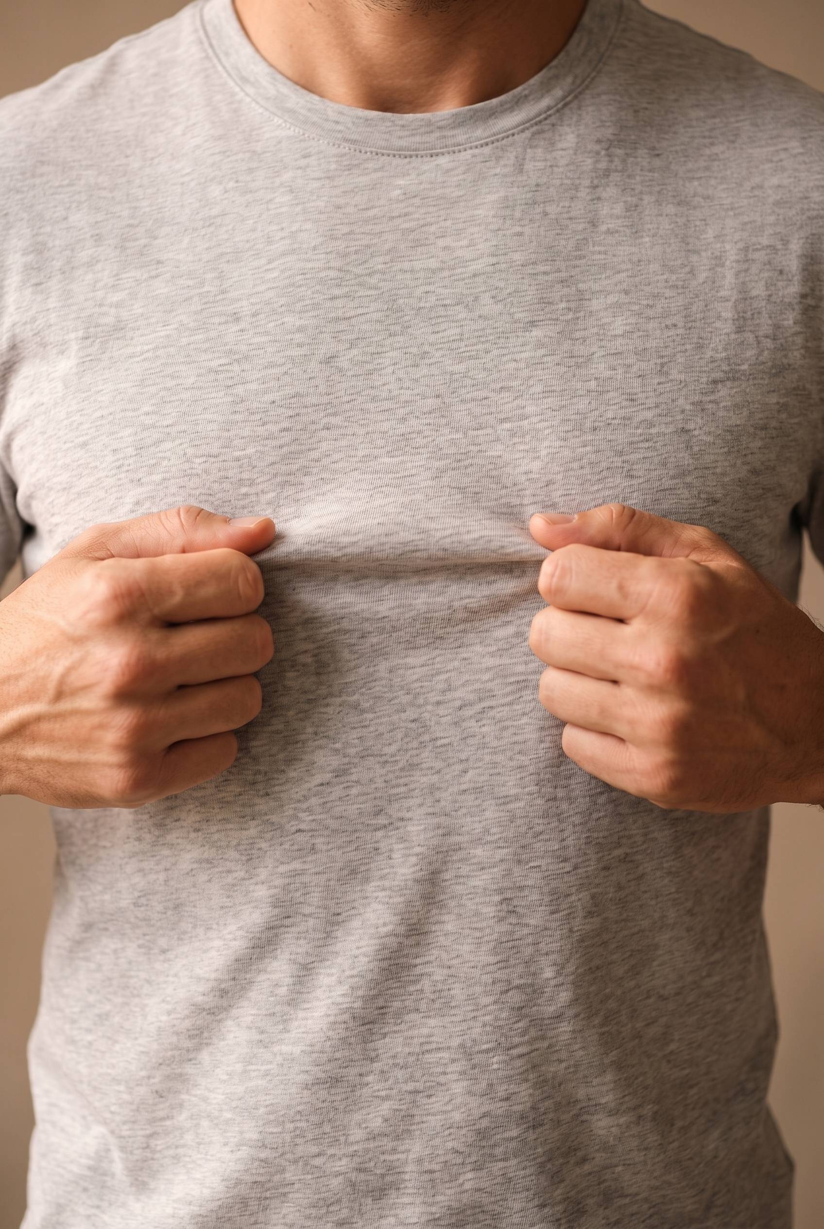 Detalle del tejido jaspe de la camiseta gris de hombre, algodon denso con veteado fino de hilo