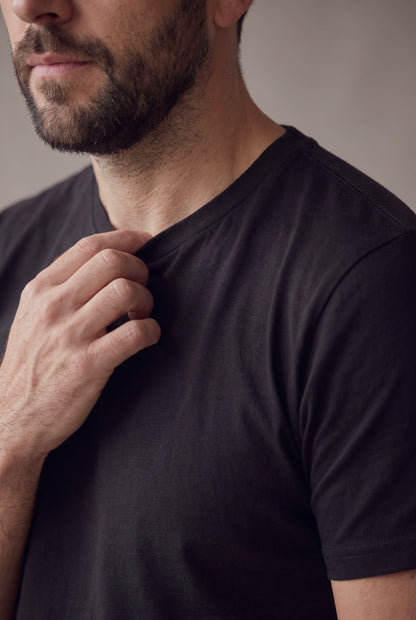 Primer plano del cuello redondo y la costura de hombro de la camiseta negra de Luck & Load.