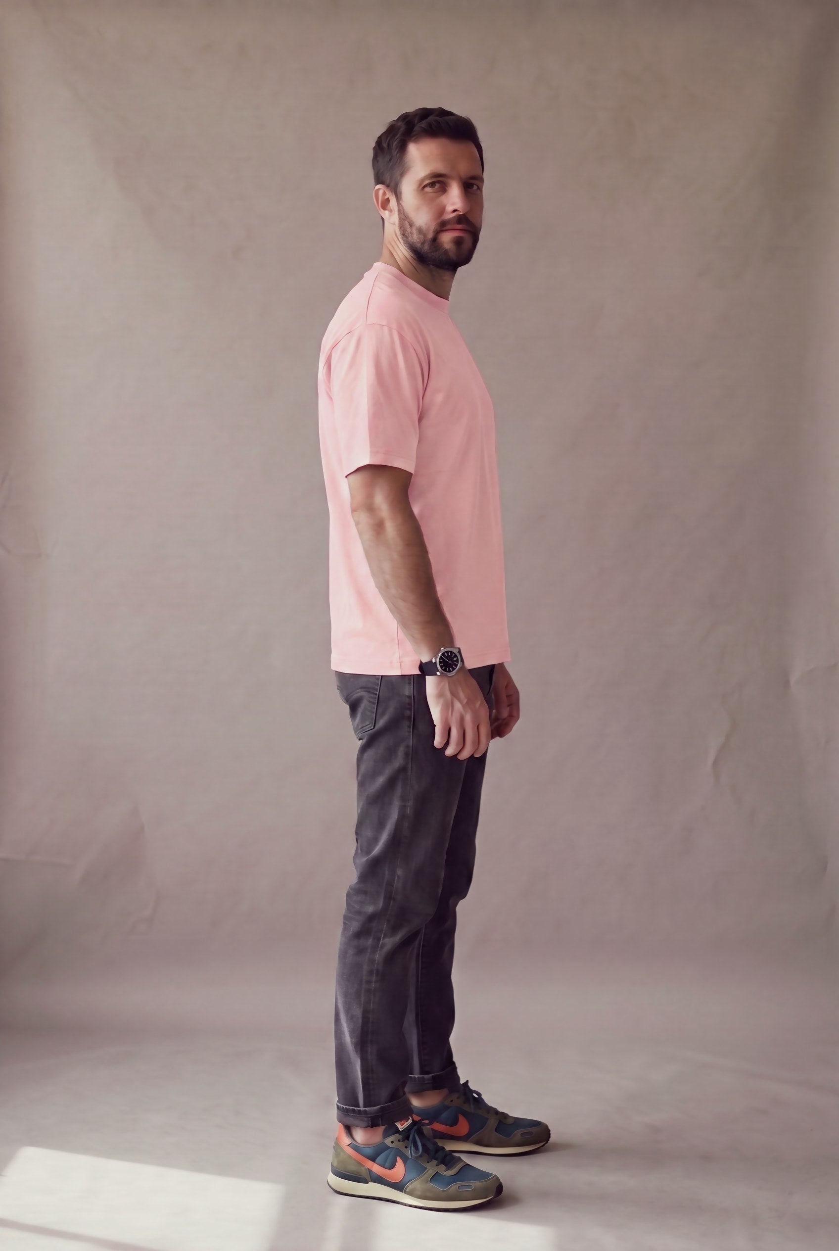 Vista lateral de la camiseta rosa palo de cuello redondo de Luck & Load sobre un hombre de pie.