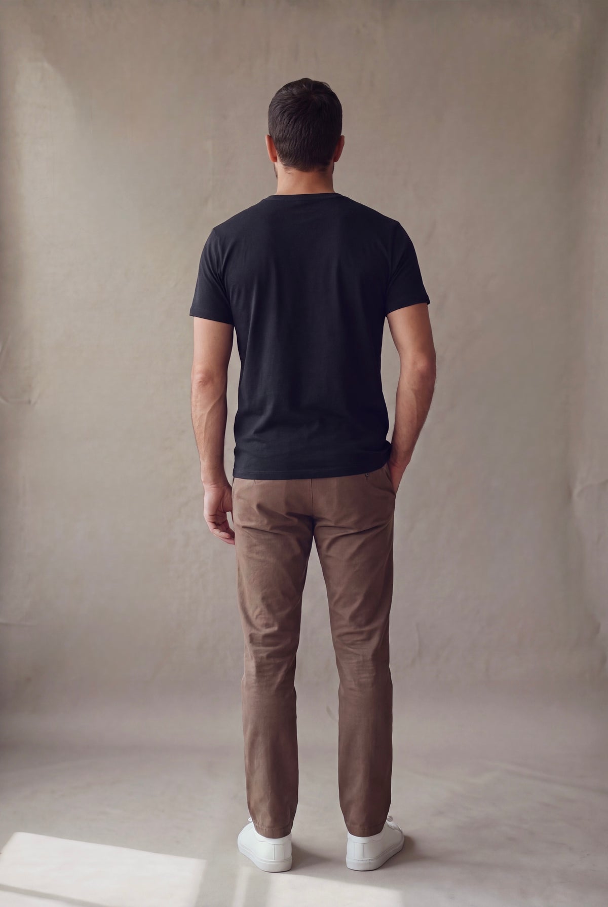 Vista de espalda de la camiseta cuello en V negra Luck and Load con pantalon cafe