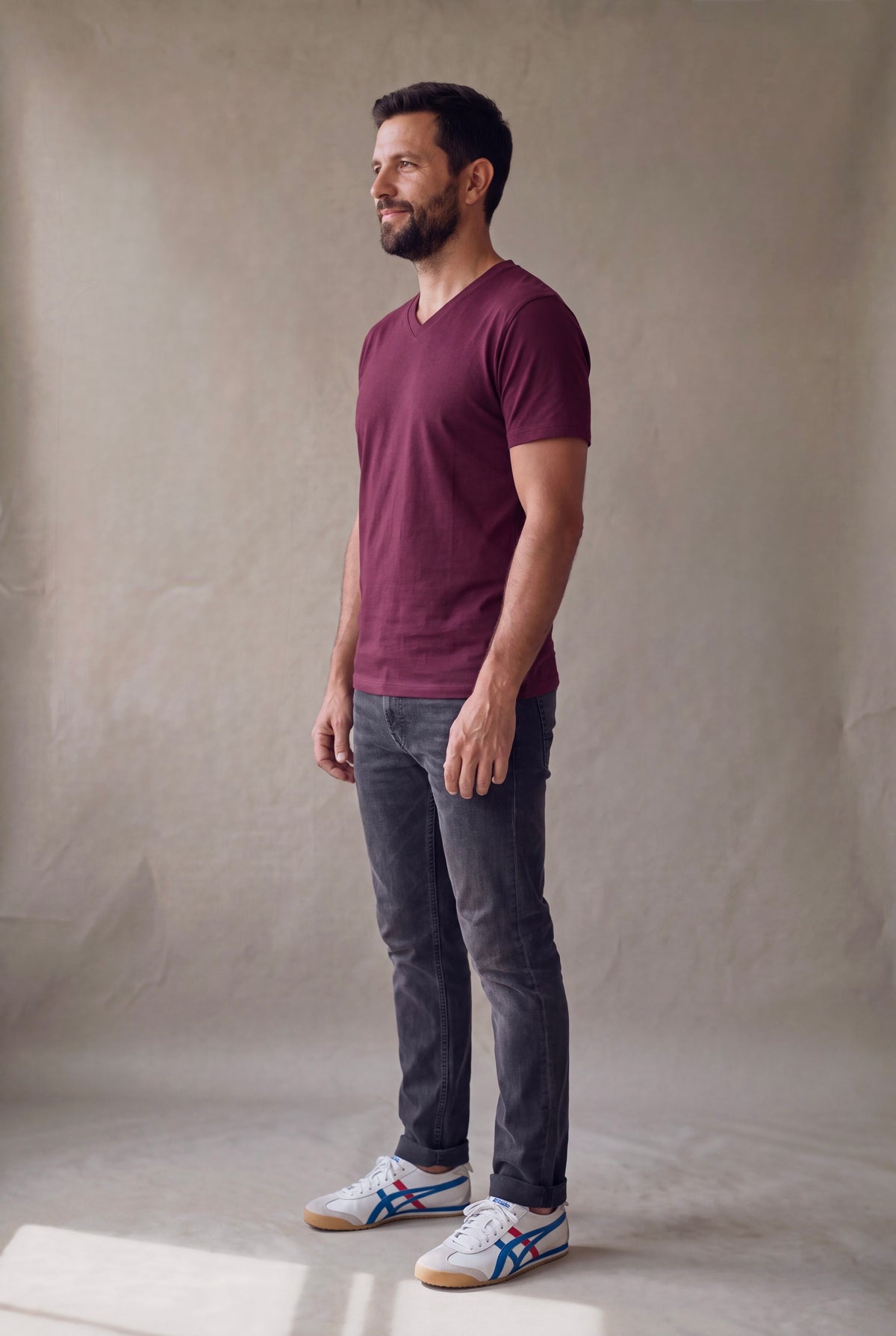 Vista lateral de la camiseta cuello en V vinotinto Luck and Load con jean gris y tenis casuales