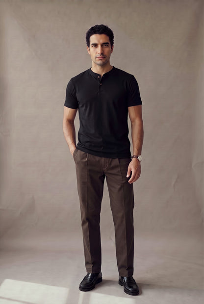 Camiseta manga corta con botones negra para hombre Luck & Load, vista de frente con pantalón café de pinza y mocasines negros
