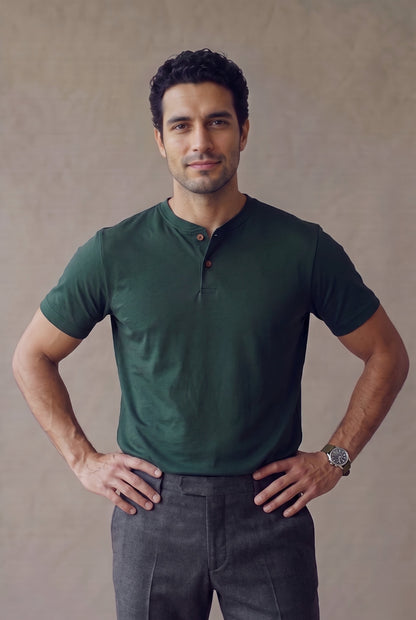 Camiseta manga corta con botones verde pino para hombre, medio cuerpo con la cartera y los dos botones de corozo a la vista
