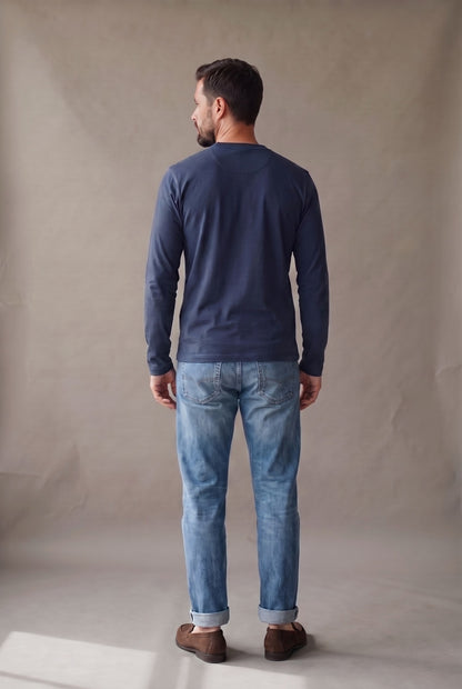 Vista de espalda de la camiseta henley manga larga azul marino con panel limpio y puños lisos.