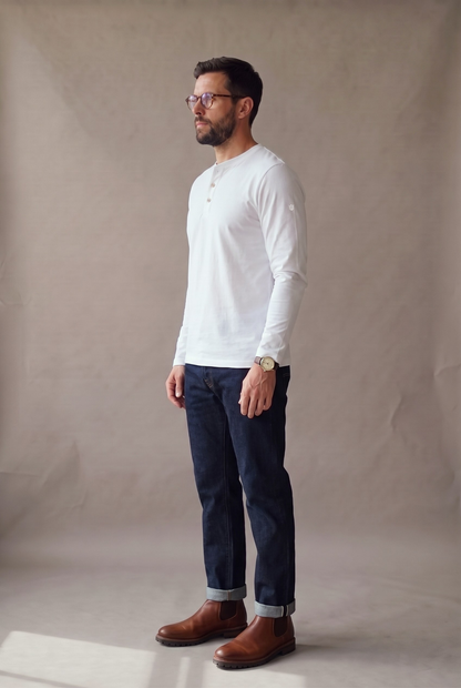 Vista lateral de la camiseta henley manga larga blanca con el largo real y la caída limpia.