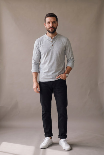 Hombre de frente con camiseta henley manga larga gris jaspe de tres botones, jean negro y tenis blancos, Luck and Load.