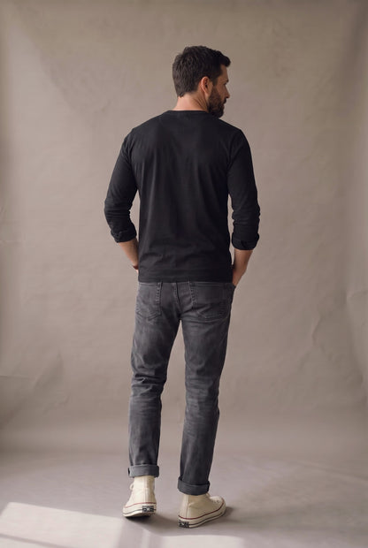 Vista de espalda de la camiseta henley manga larga negra con panel liso y puños lisos.