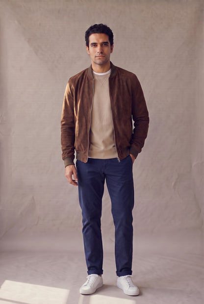Chaqueta bomber café de gamuza para hombre, abierta sobre camiseta blanca, de Luck & Load.