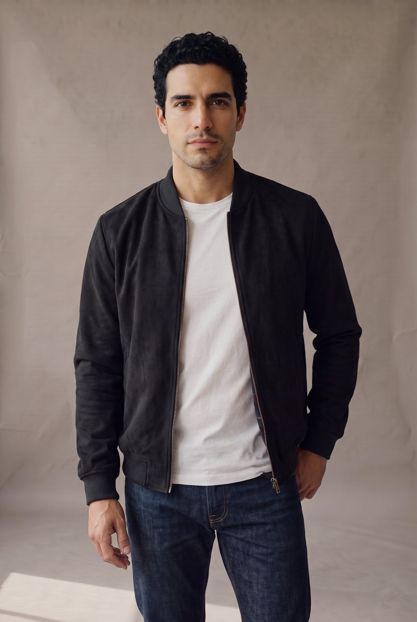 Chaqueta bomber negra de gamuza para hombre, abierta sobre camiseta blanca, de Luck & Load.