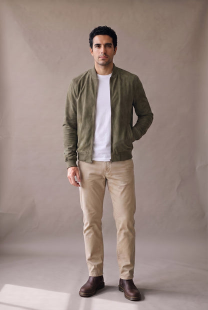 Chaqueta bomber verde militar de gamuza para hombre, abierta sobre camiseta blanca, de Luck & Load.
