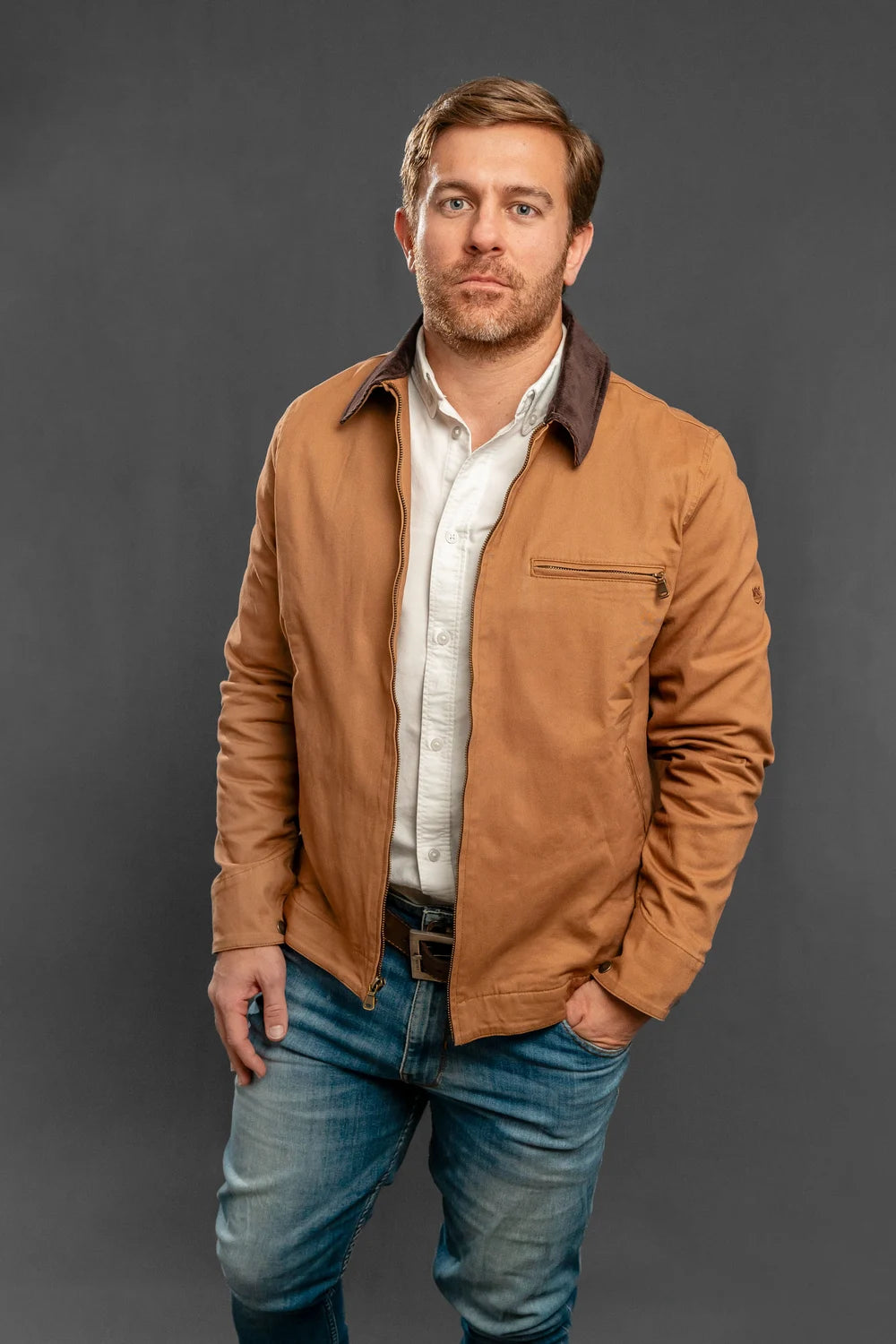 Chaqueta trucker camel de algodón resistente para hombre, cuello de pana café y cierre frontal metálico, estilo urbano colombiano.