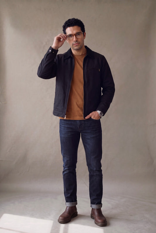Chaqueta Detroit verde oliva para hombre de Luck & Load: chaqueta obrera de cuello de pana, abierta sobre oxford celeste y camiseta blanca, con jean claro y loafers, casual premium.