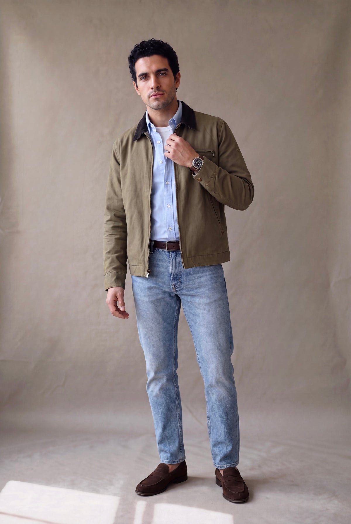 Chaqueta Detroit verde oliva para hombre de Luck & Load: chaqueta obrera de cuello de pana, abierta sobre oxford celeste y camiseta blanca, con jean claro y loafers, casual premium.