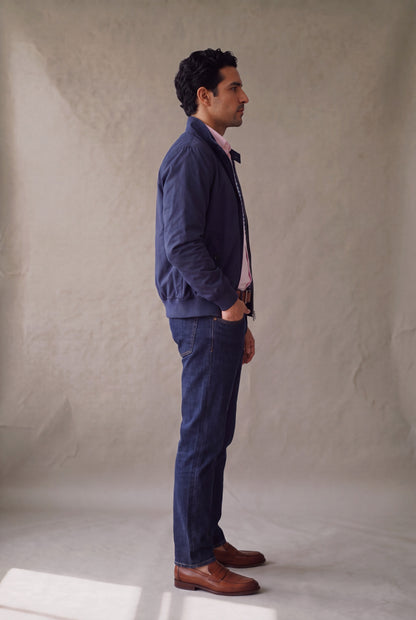 Vista lateral de la chaqueta Harrington azul marino de Luck & Load sobre camisa oxford palo de rosa.
