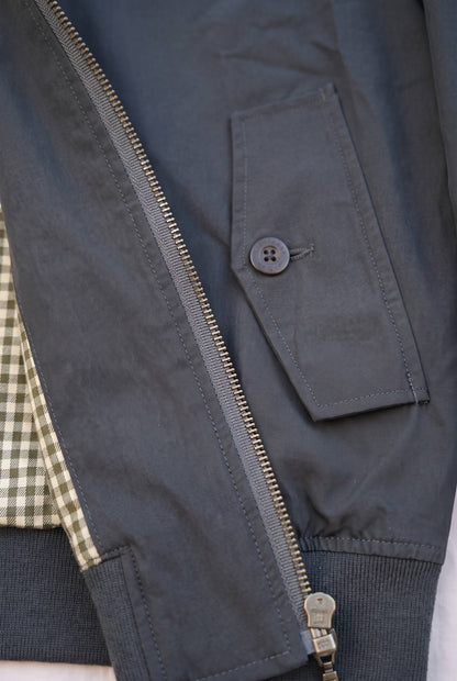 Primer plano de los bolsillos y el tejido de la chaqueta Harrington negra de Luck & Load.