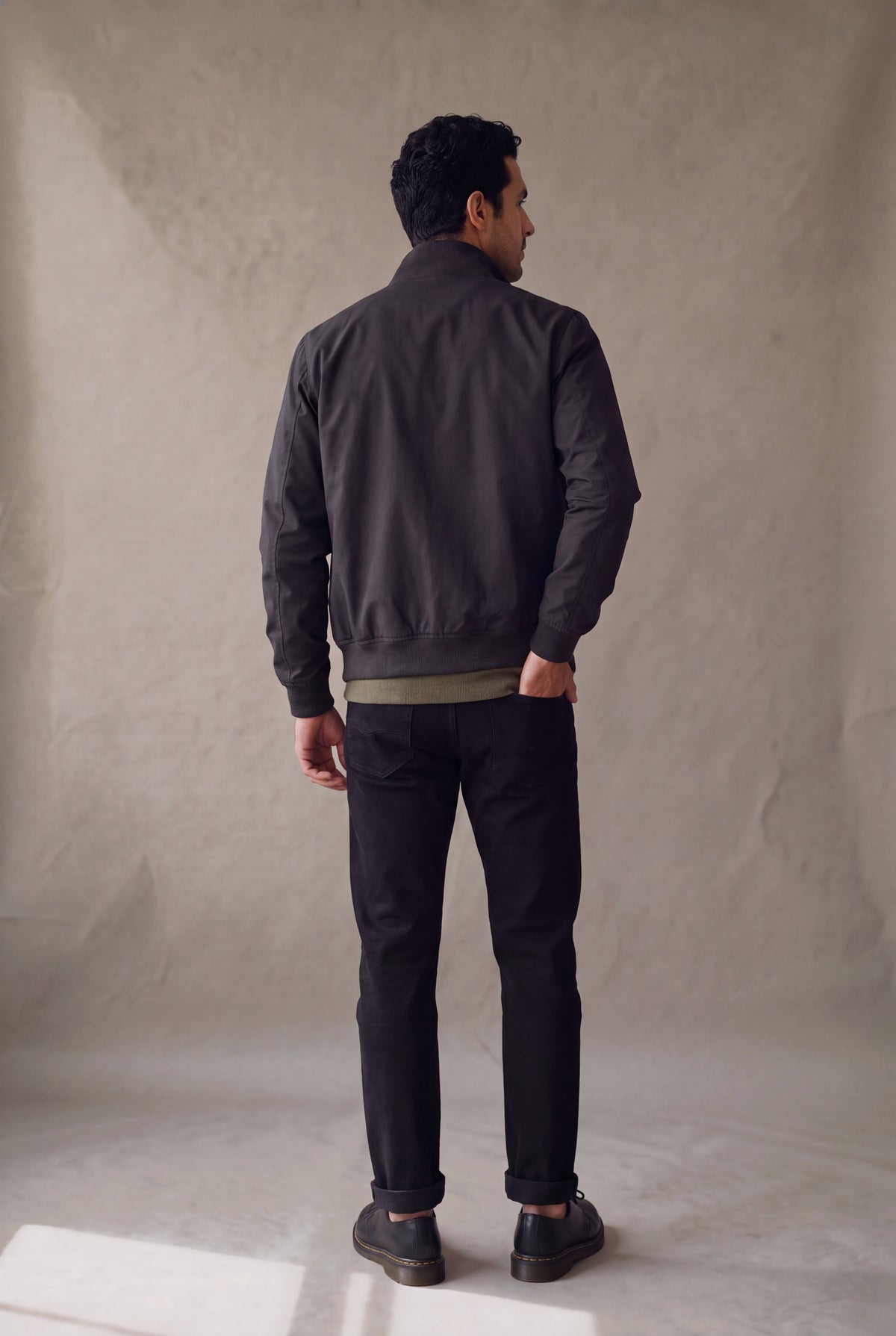 Vista de espalda de la chaqueta Harrington negra de Luck & Load, corte recto y largo a la cadera.