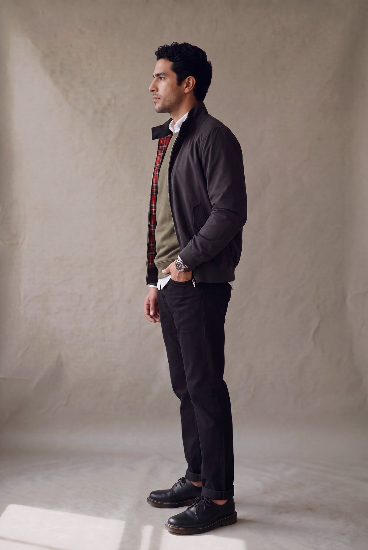 Vista lateral de la chaqueta Harrington negra de Luck & Load sobre jean negro y botas cafe.