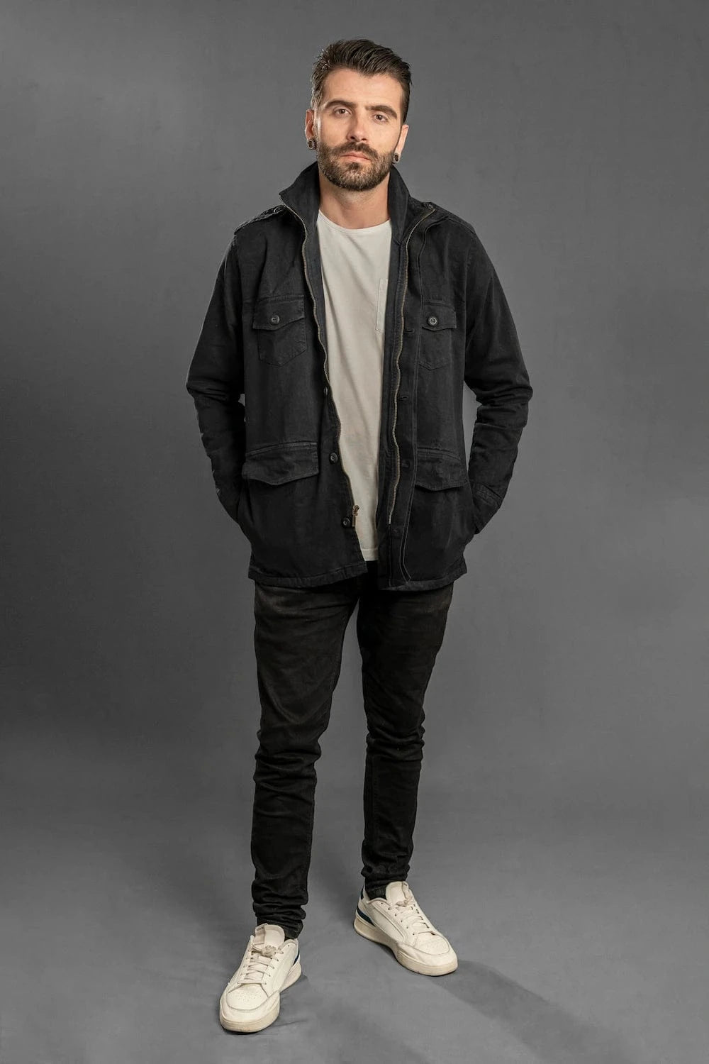 Chaqueta militar negra Luck & Load para hombre — vista frontal cuerpo entero con jeans, cuello alto, outfit casual contemporáneo