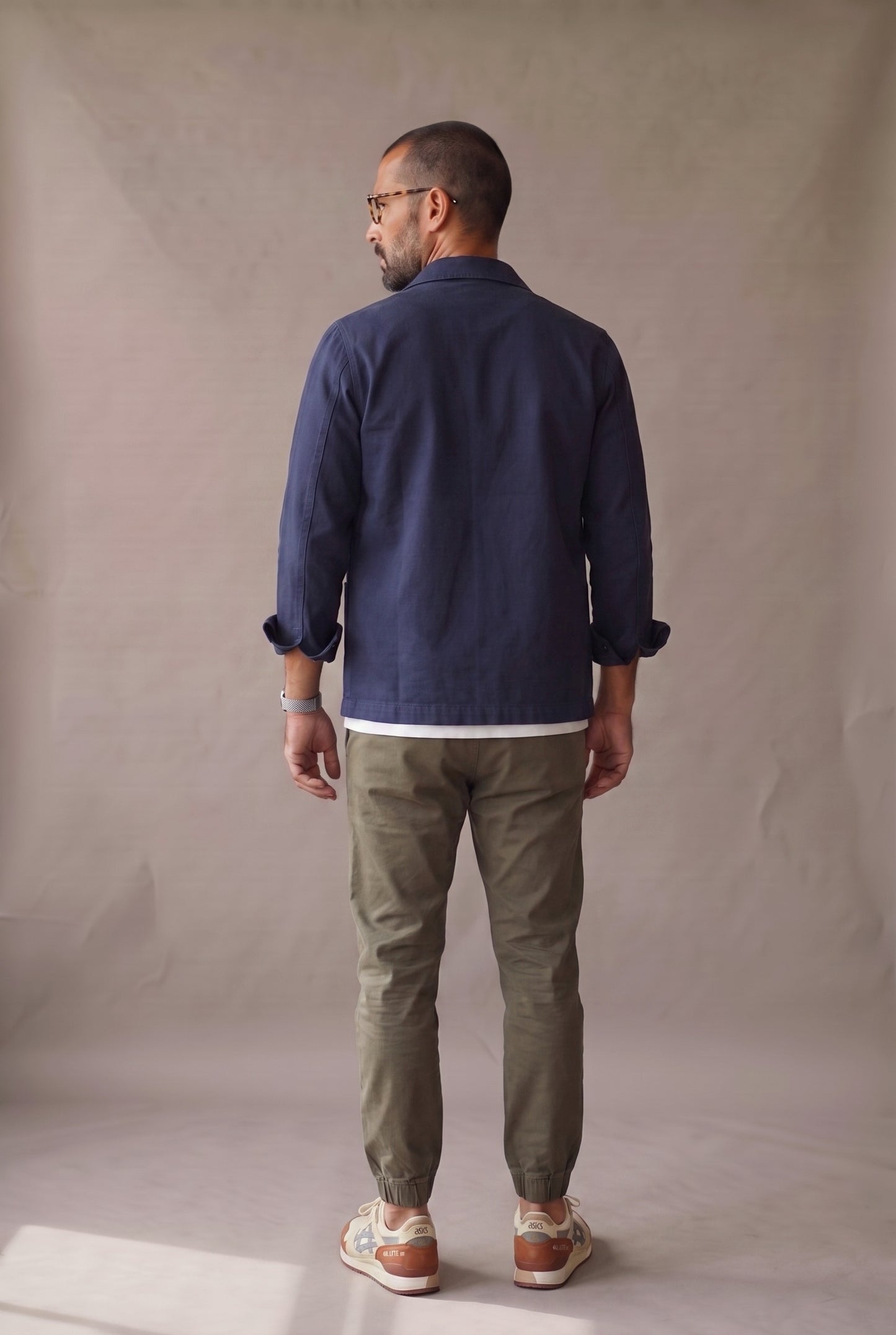 Chaqueta obrera azul marino para hombre de Luck & Load, vista de espalda con el paño trasero liso, sin costura horizontal.