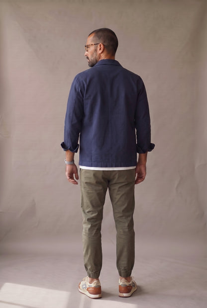 Chaqueta obrera azul marino para hombre de Luck & Load, vista de espalda con el paño trasero liso, sin costura horizontal.