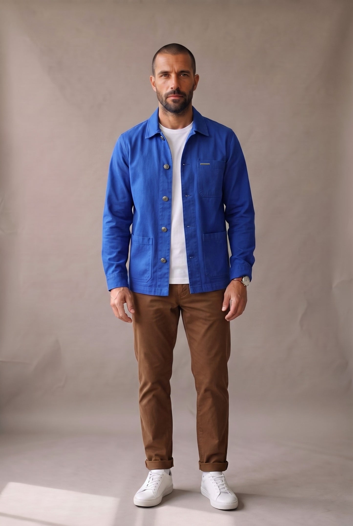 Chaqueta obrera azul rey para hombre de Luck & Load, vista frontal de cuerpo entero sobre camiseta blanca y pantalón café.
