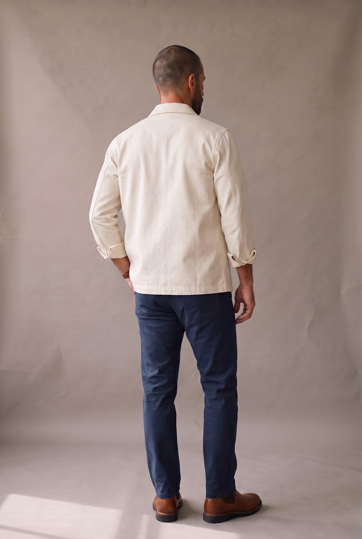 Chaqueta obrera beige para hombre de Luck & Load, vista de espalda con el paño trasero liso, sin costura horizontal.