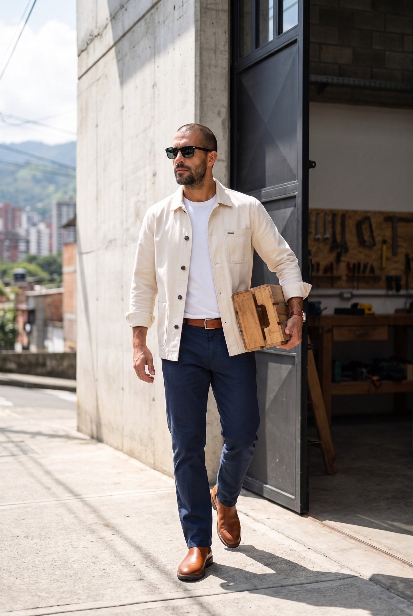 Hombre con chaqueta obrera beige de Luck & Load caminando por una calle de Medellín, foto de estilo de vida en exteriores.