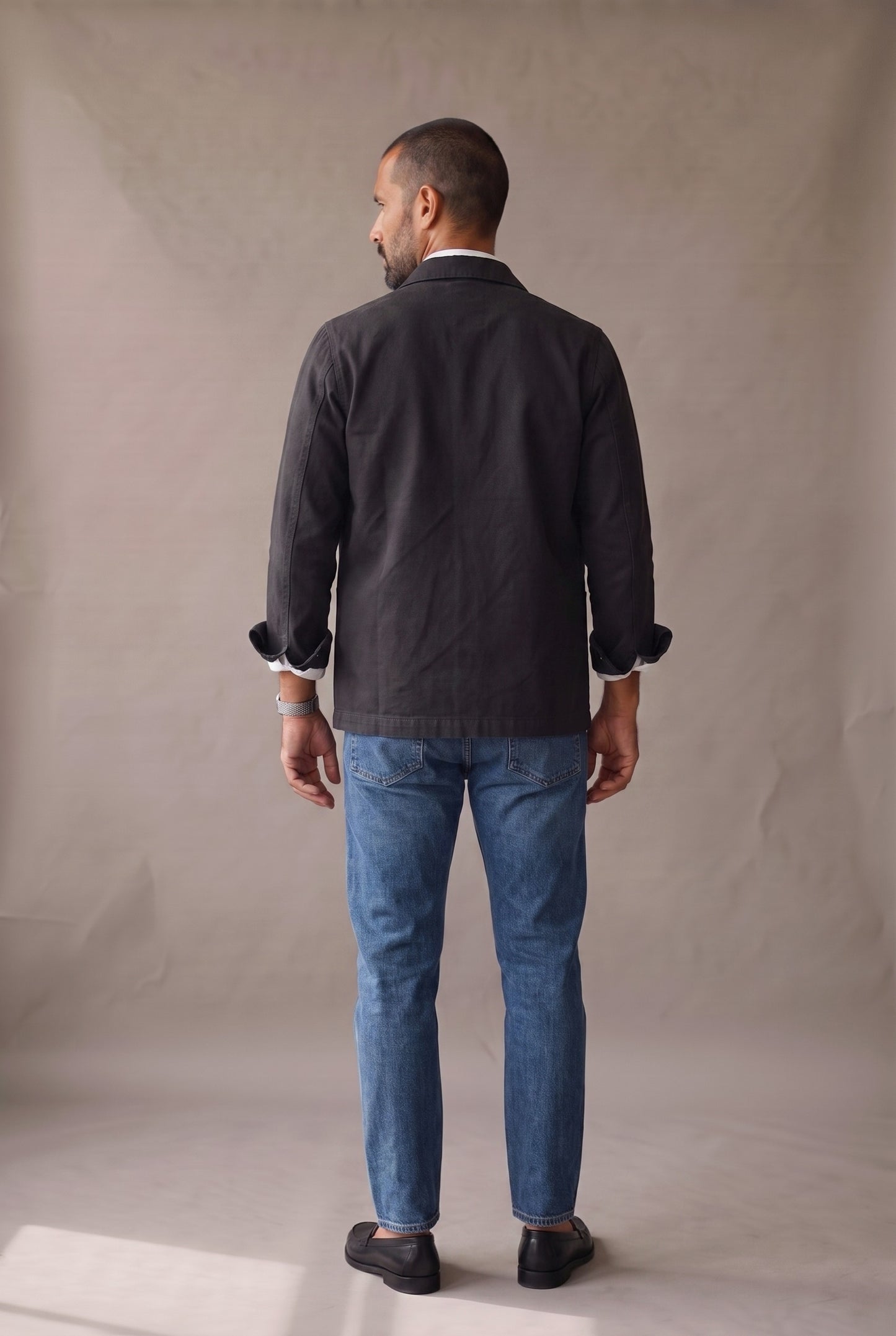 Chaqueta obrera negra para hombre de Luck & Load, vista de espalda con el paño trasero liso, sin costura horizontal.