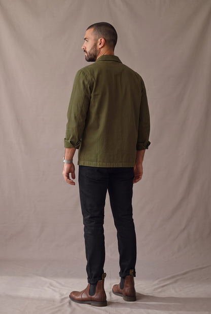 Chaqueta obrera verde militar para hombre de Luck & Load, vista de espalda con el paño trasero liso, sin costura horizontal.