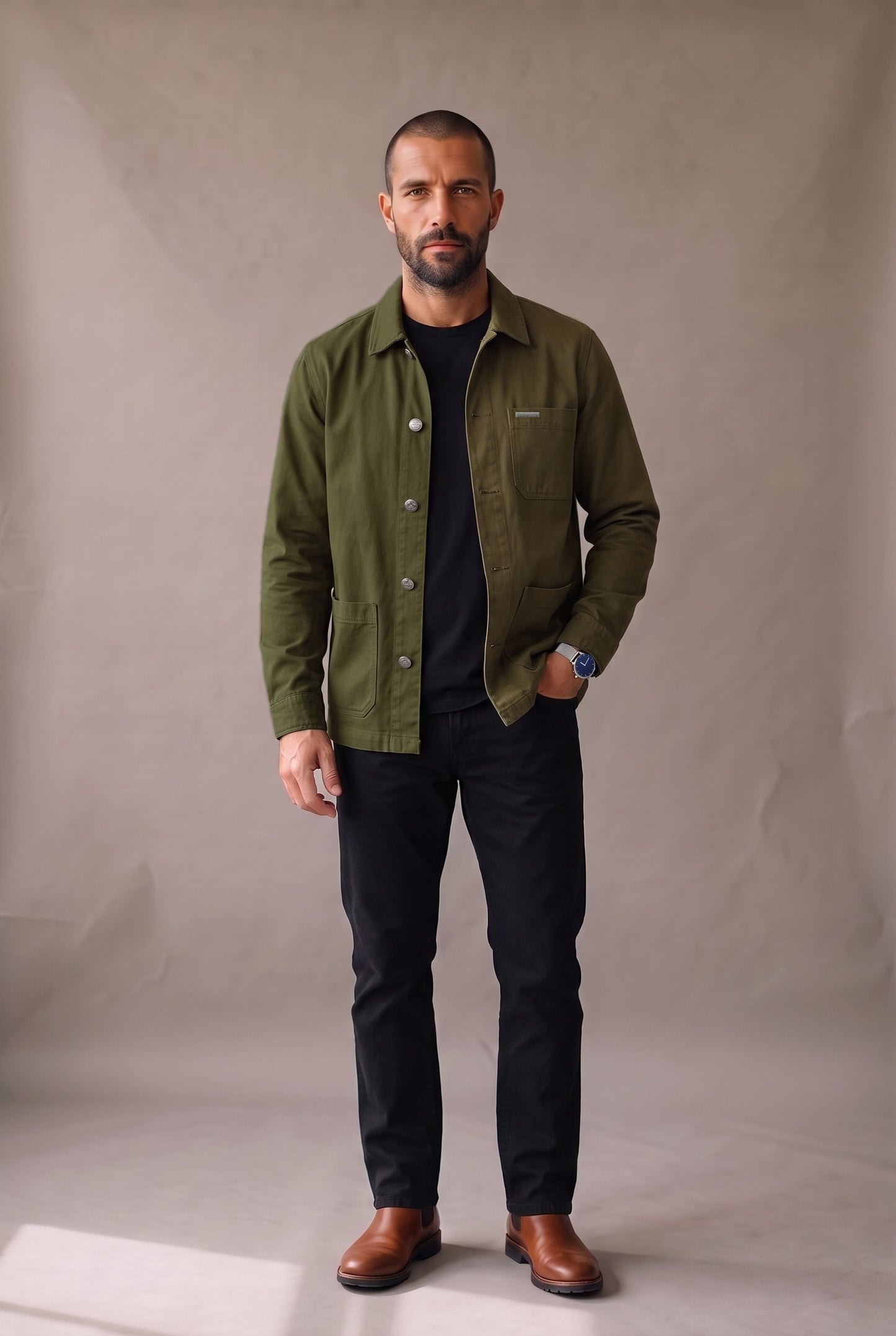 Chaqueta obrera verde militar para hombre de Luck & Load, vista frontal de cuerpo entero, abierta sobre camiseta negra y jean negro.