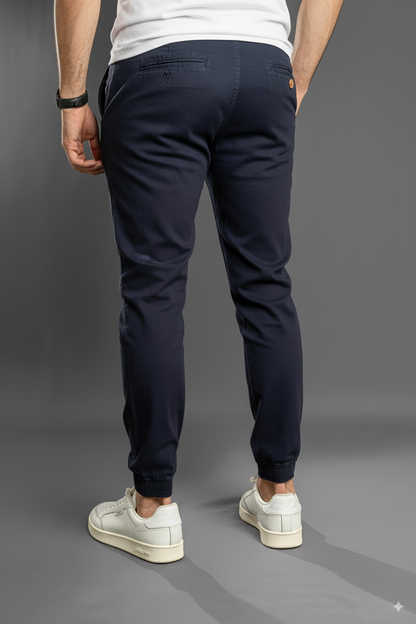 Vista trasera de pantalón jogger azul marino, puños resortados y corte tapered para uso diario