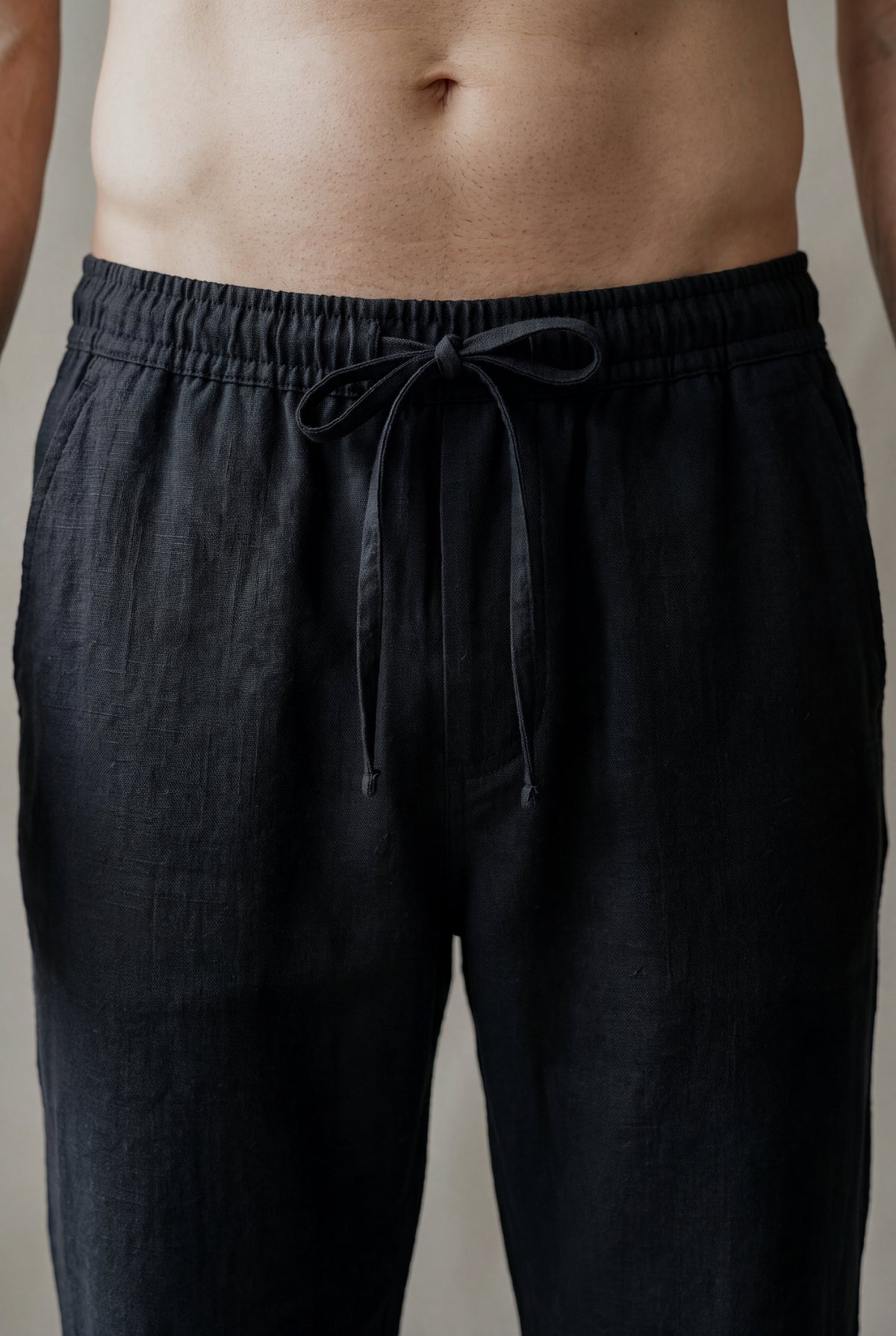 Detalle de la pretina elástica con cordón y moño del pantalón de descanso en lino negro, Luck & Load